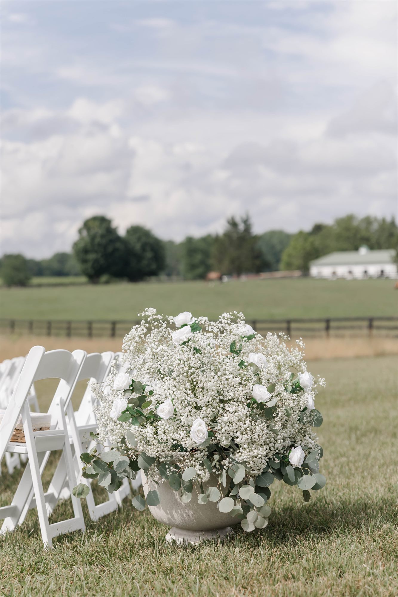 White flowers lining the ceremony aisle in the field