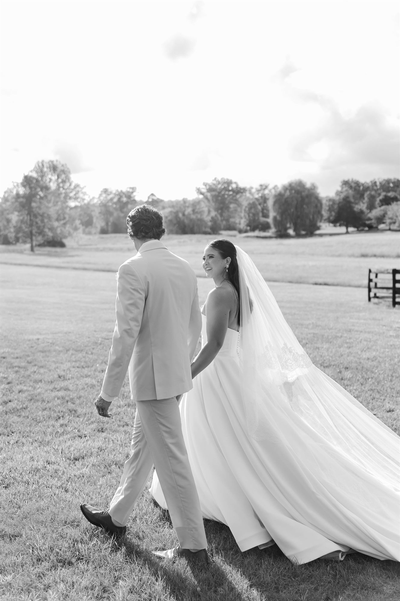 Couple walking past the paddock in black and white