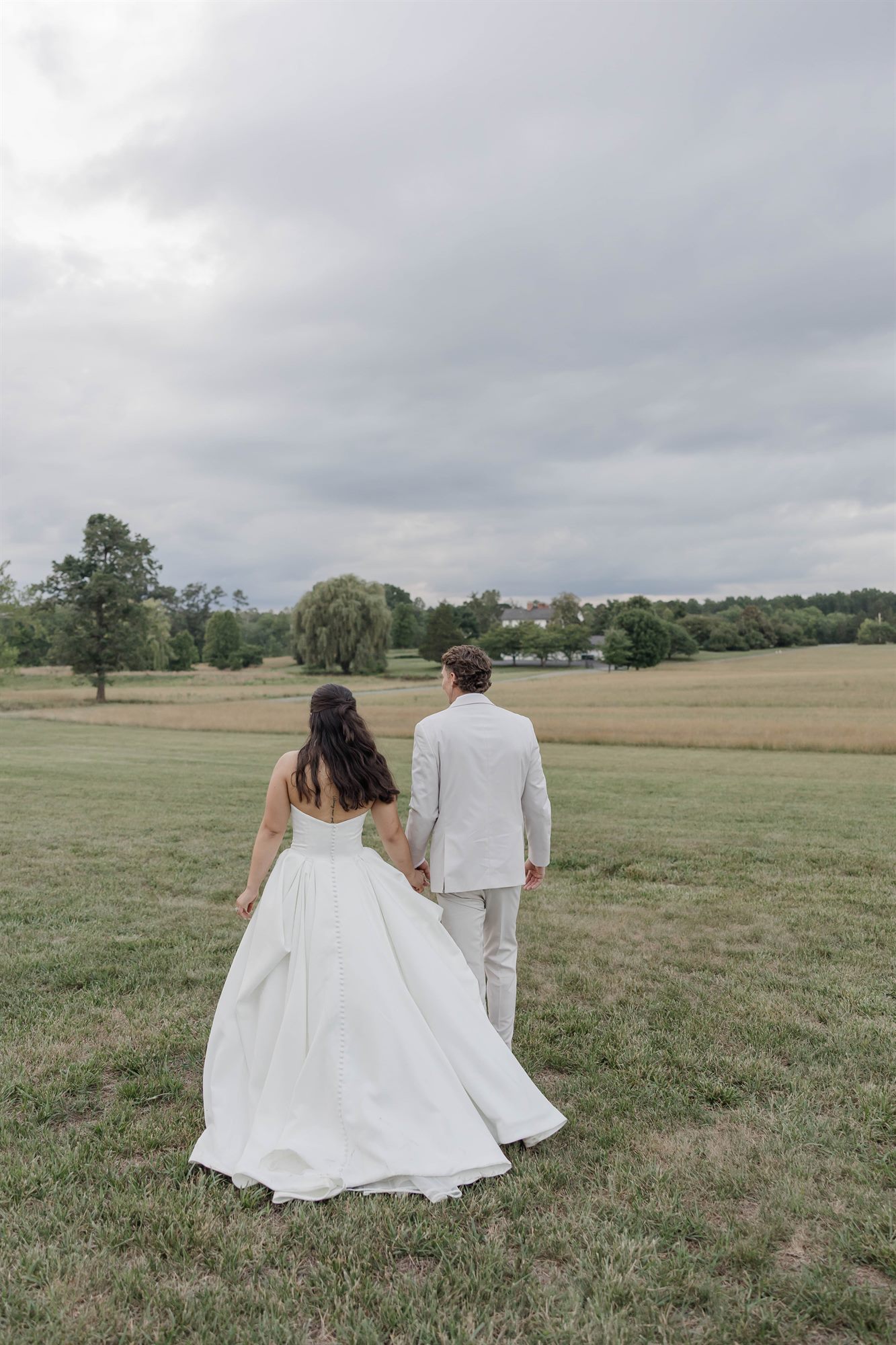 Bride and groom walking into the field