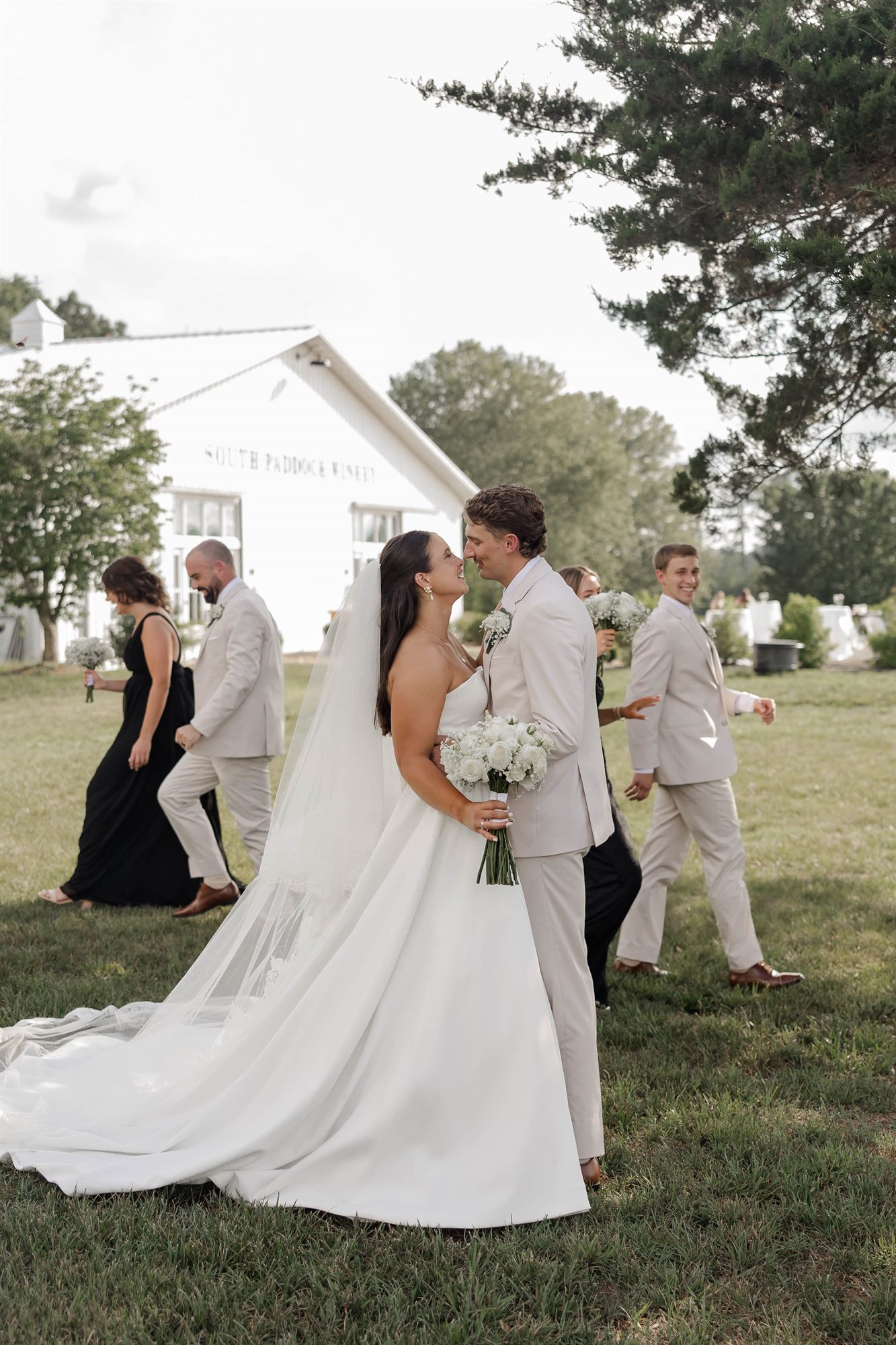 Bride and groom with the white barn behind them