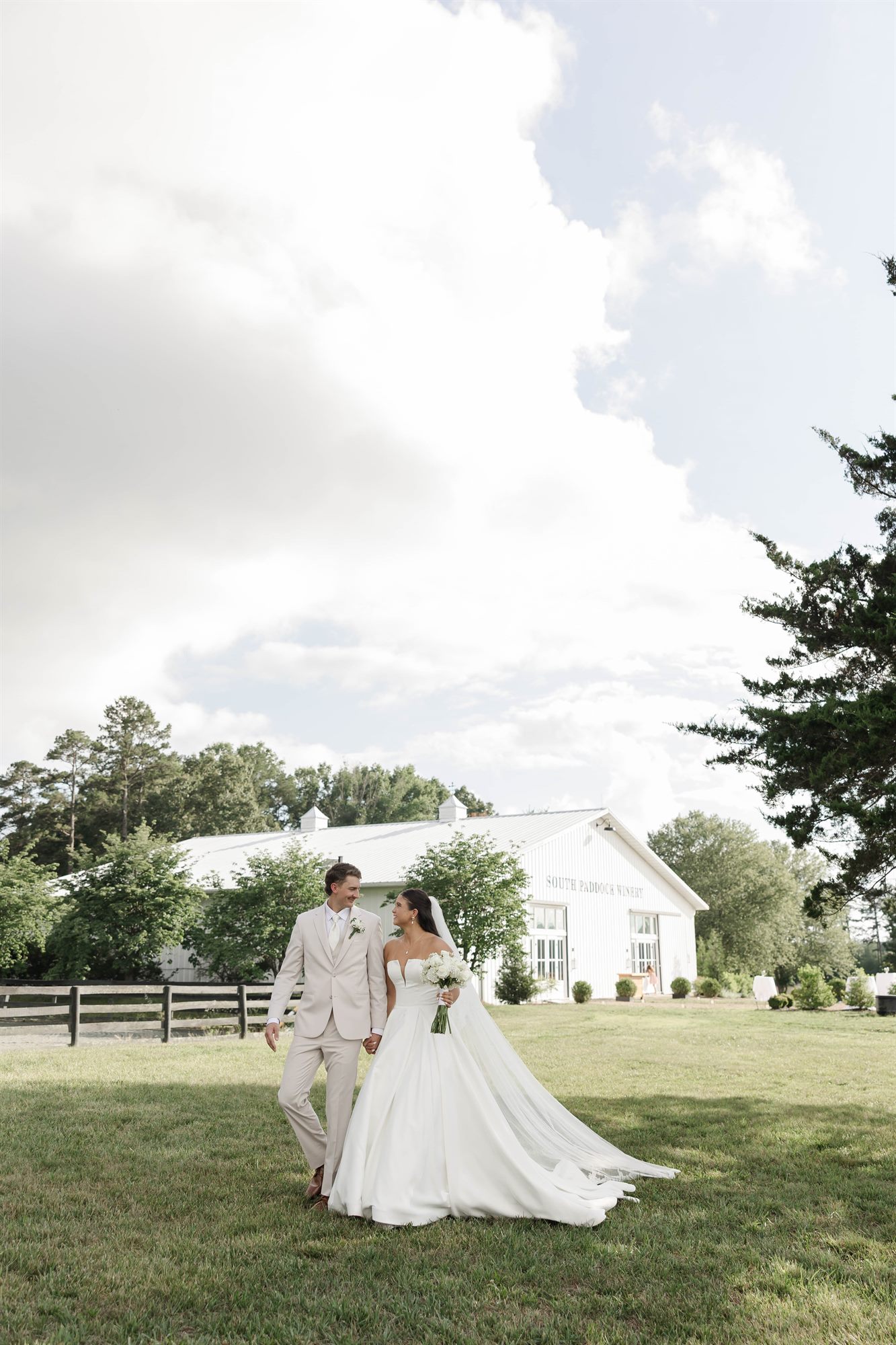 Couple on the lawn in front of the white barn